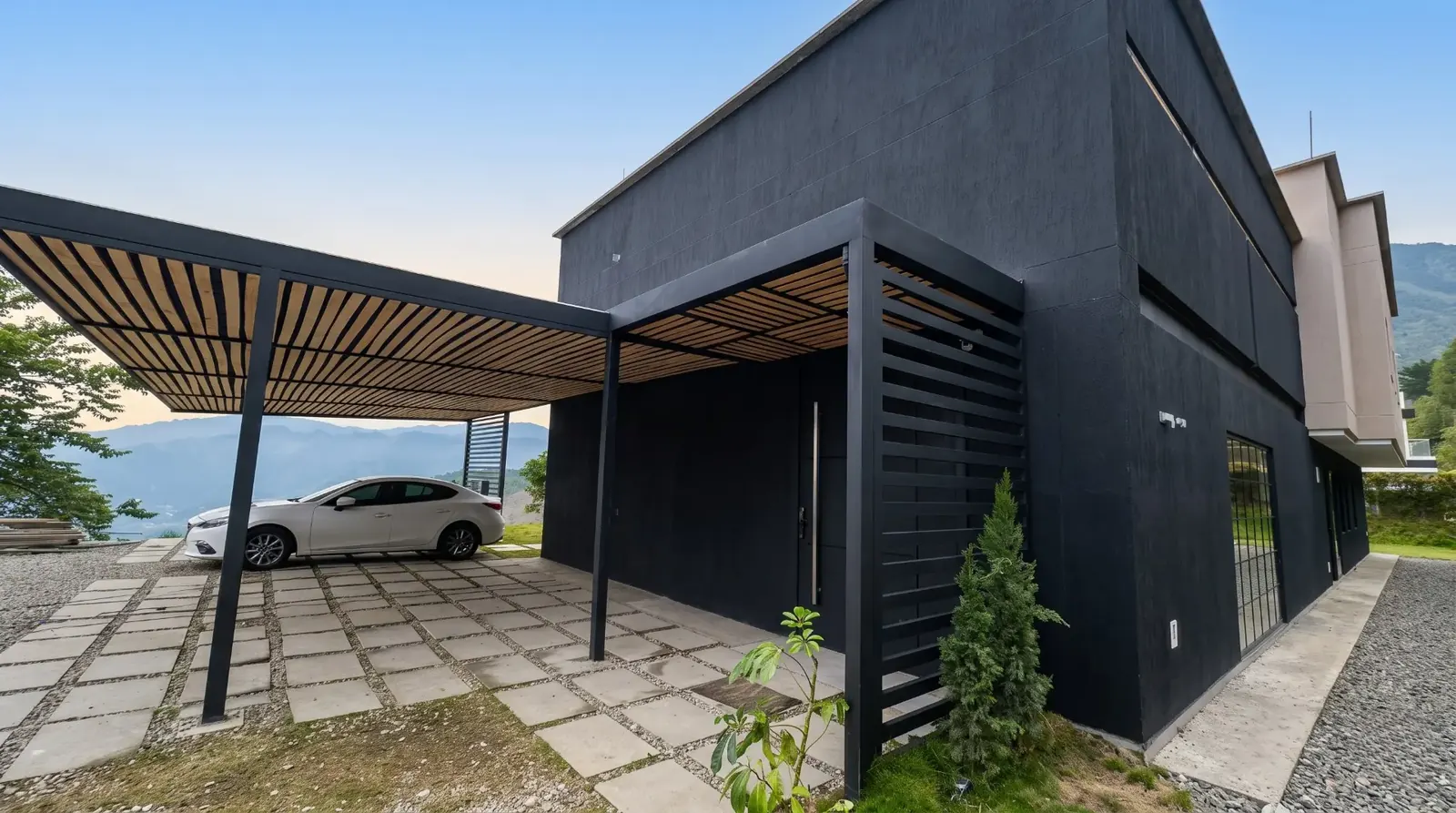 Casa negra con pérgola y parqueadero